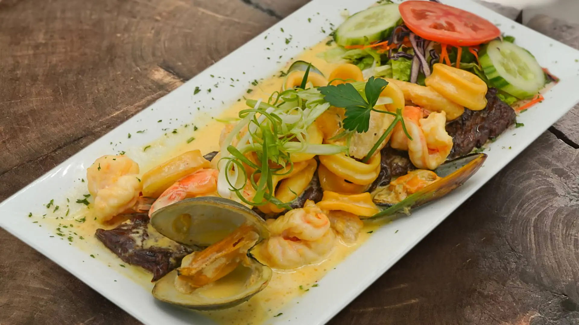 Skirt steak with seafood cream on square plate